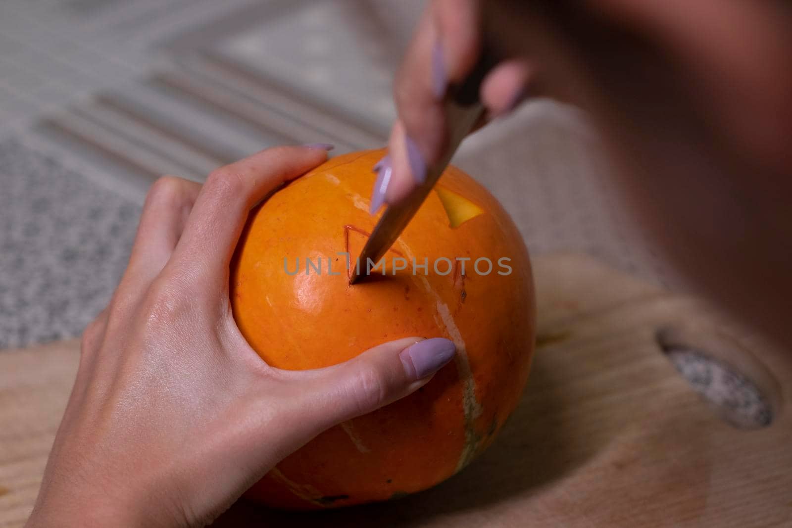 the process of making a Halloween pumpkin. cutting out eyes. horror theme and Hallowe'en.