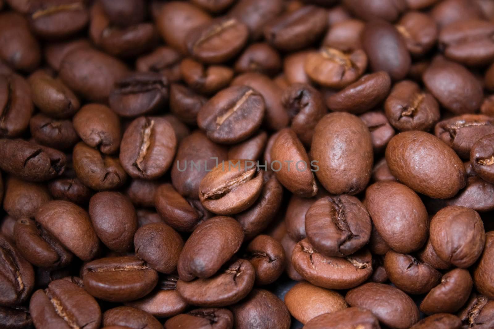 close up of Freshly roasted coffee beans background. top view by oliavesna