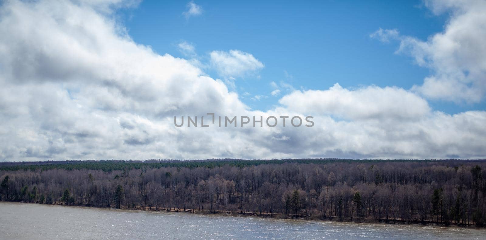 A beautiful, wide river in the spring among the forests. Quiet and peaceful place. Not clear, muddy water in the river. Top view of the distance