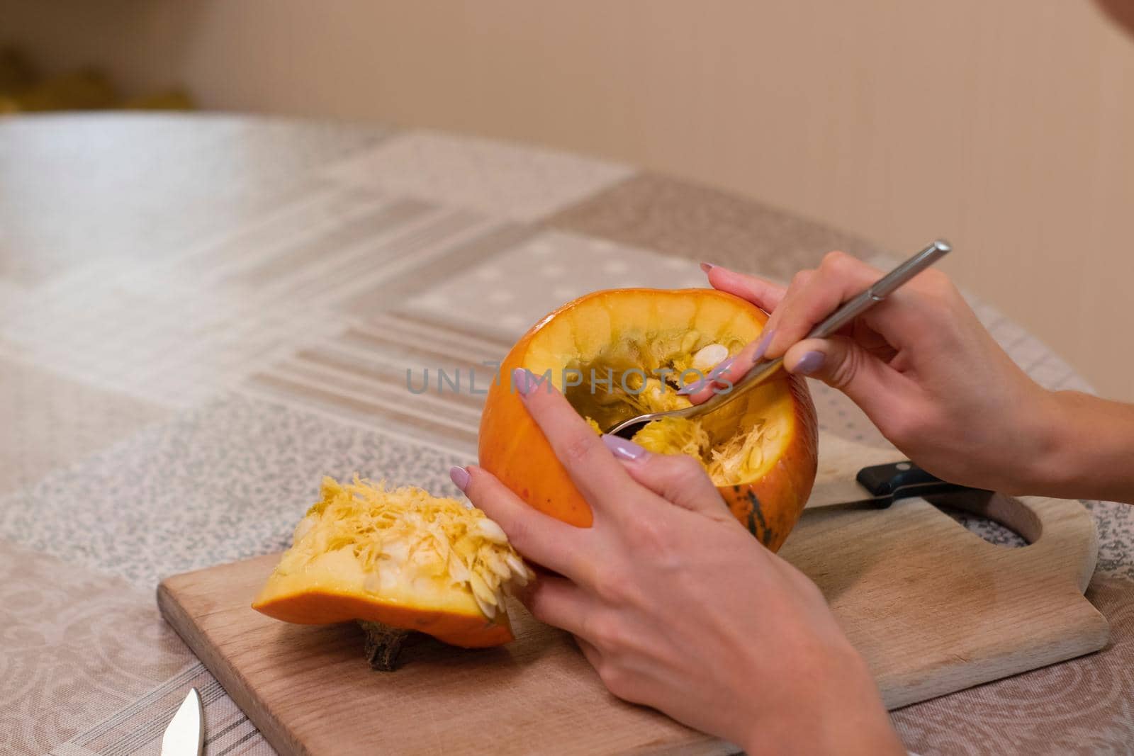 the process of making a Halloween pumpkin. cleansing of seeds by a brunette girl. horror theme and Hallowe'en.