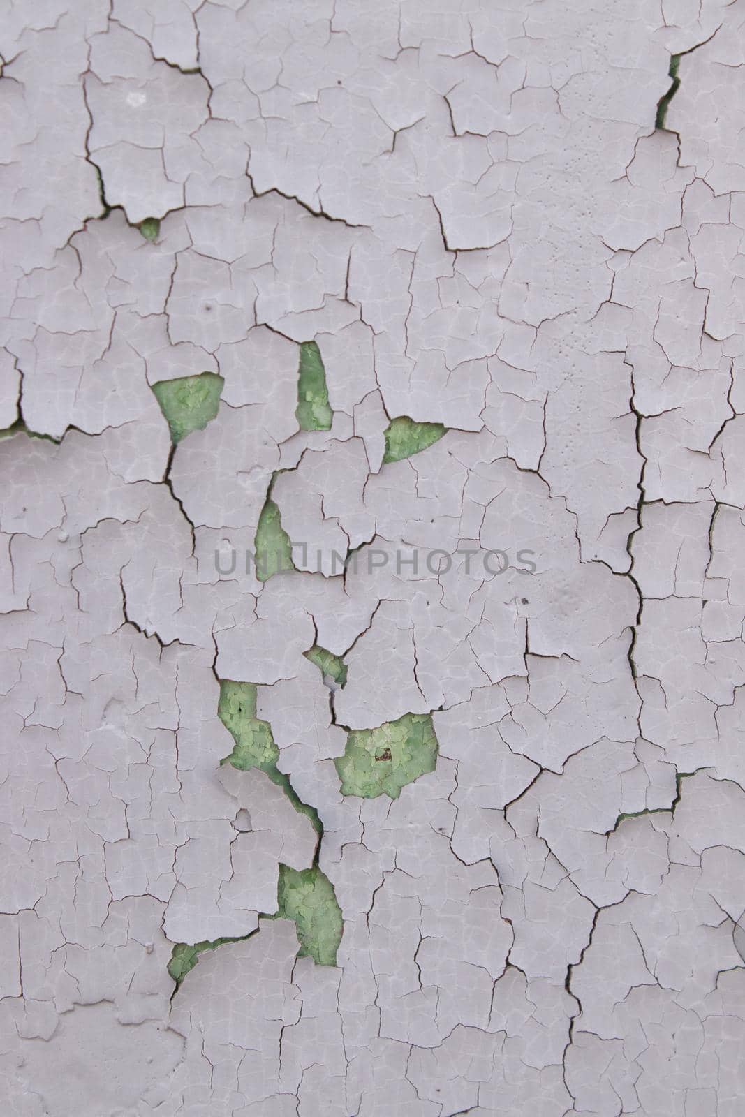 Old cracked paint on wall. Texture, pattern, background. The wall cracked with paint, abstract paint behind the iron. close up by oliavesna