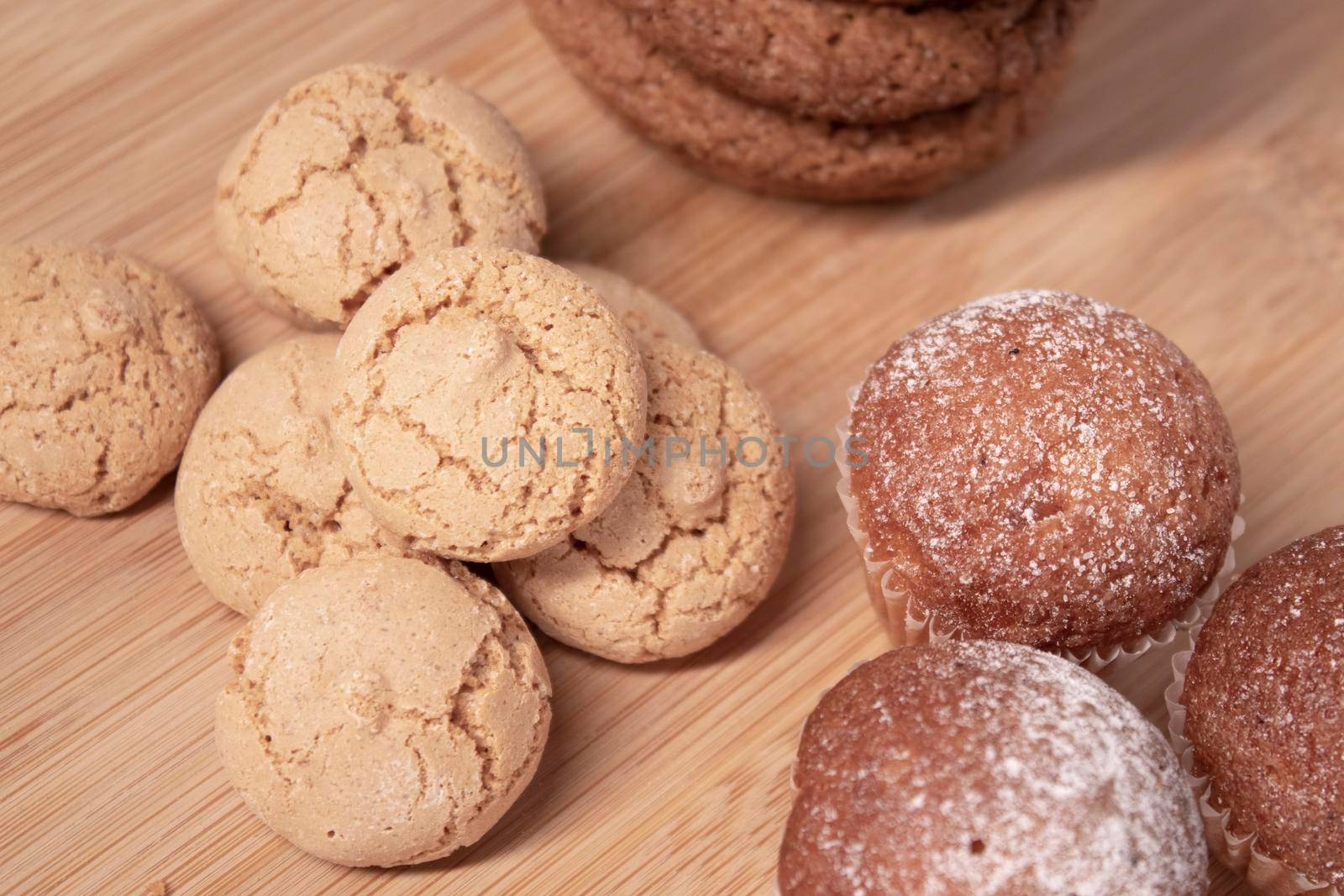 muffins, almond amaretti and oat cookies on wooden stand board. concept of sweet bakery