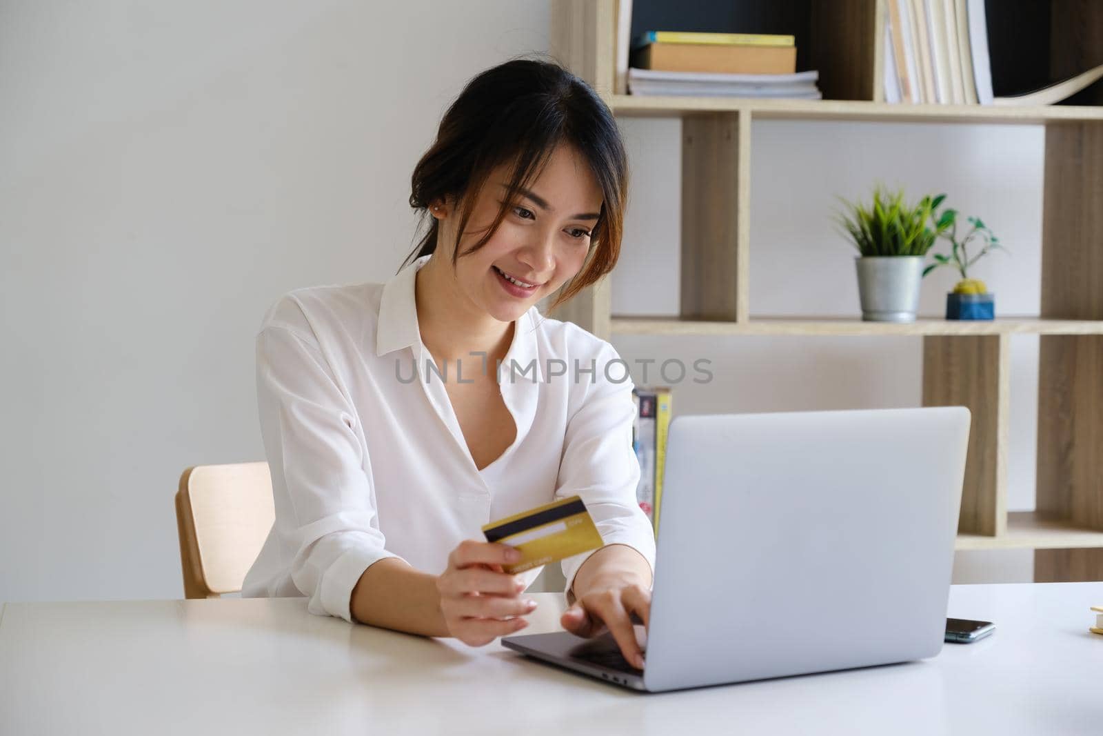 Woman enjoy with online shopping application and looking at laptop for fill credit card number to payment. by itchaznong