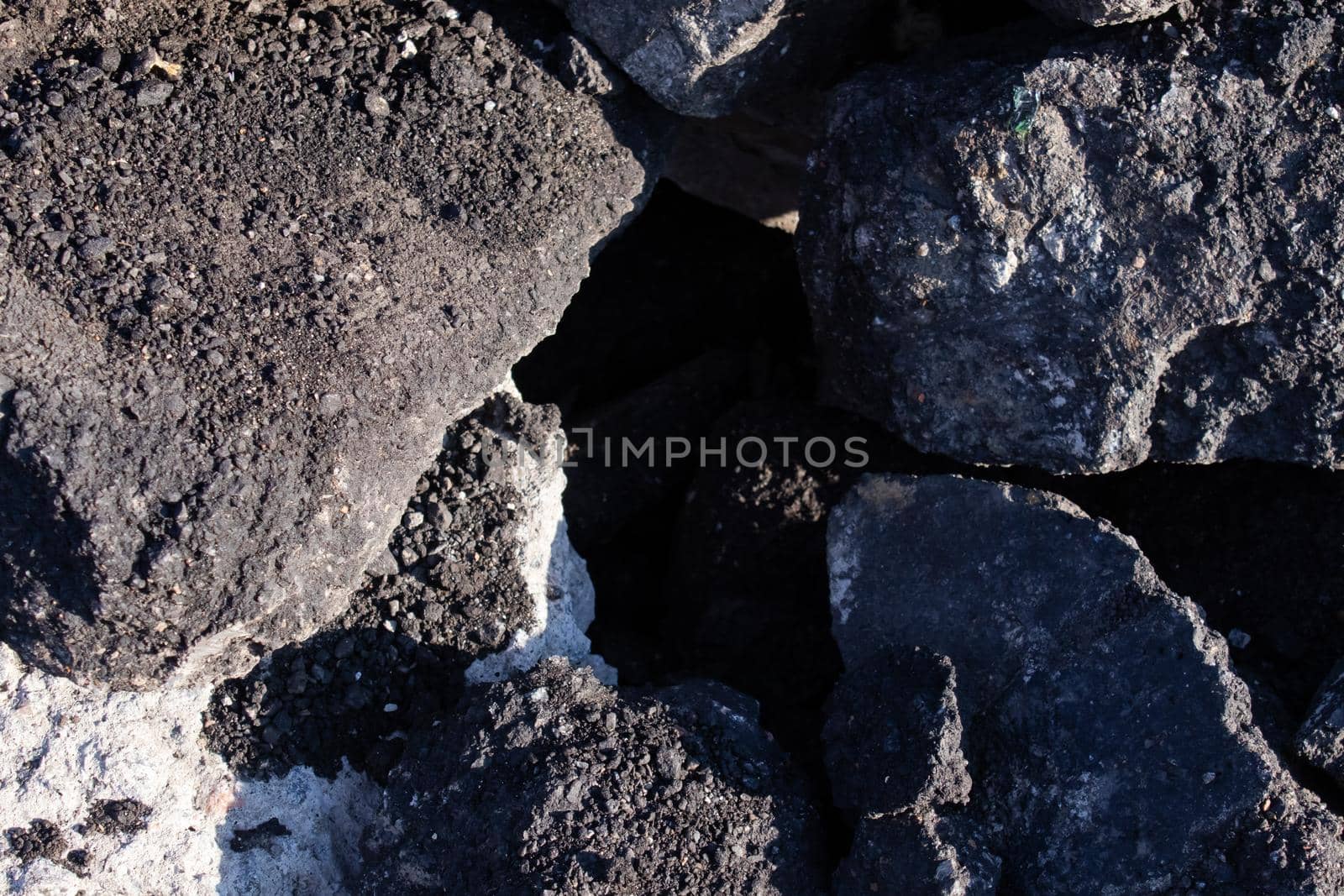 close-up of Old cracked asphalt pavement. concept of reduce reuse recycle. pile of smashed concrete. Disaster results, earthquake or accident. Destroyed highway, damage and collapse by oliavesna
