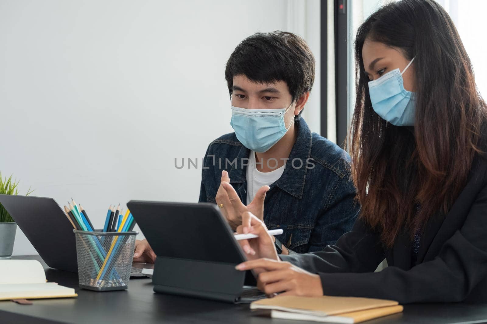 Asian business people have a meeting and working in office and wear mask as protection from corona virus