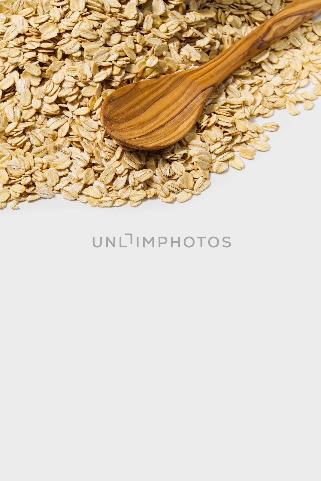 Oat flakes with wooden spoon isolated on white background. healthy, dieting food concept