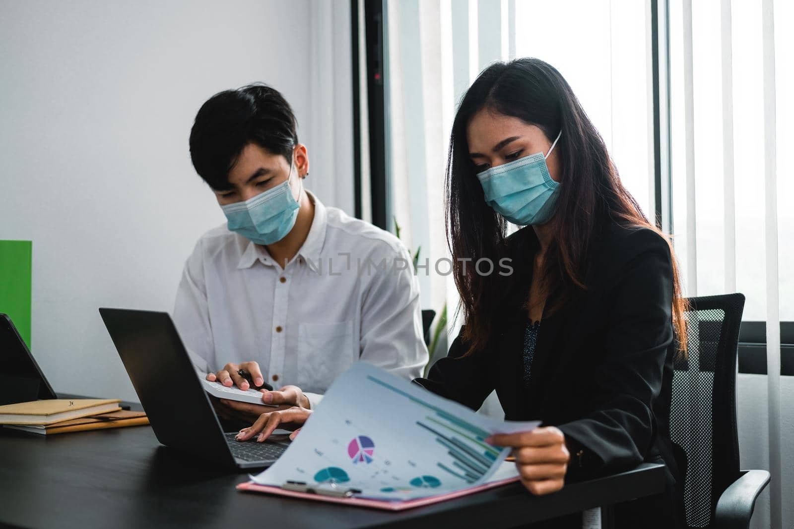 Asian business people have a meeting and working in office and wear mask as protection from corona virus