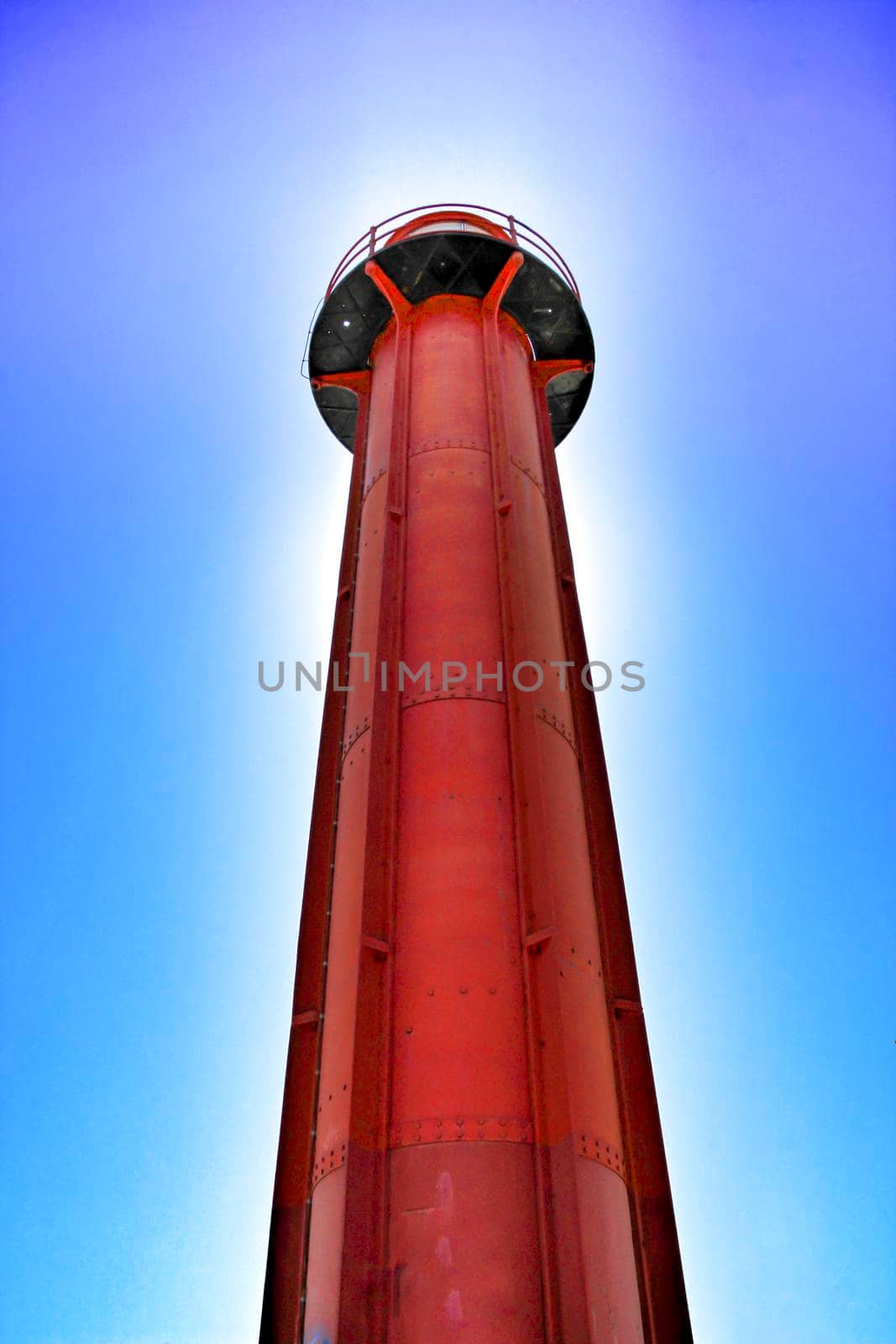 Red lighthouse in the port of Almada village in Lisbon on a sunny day of winter.