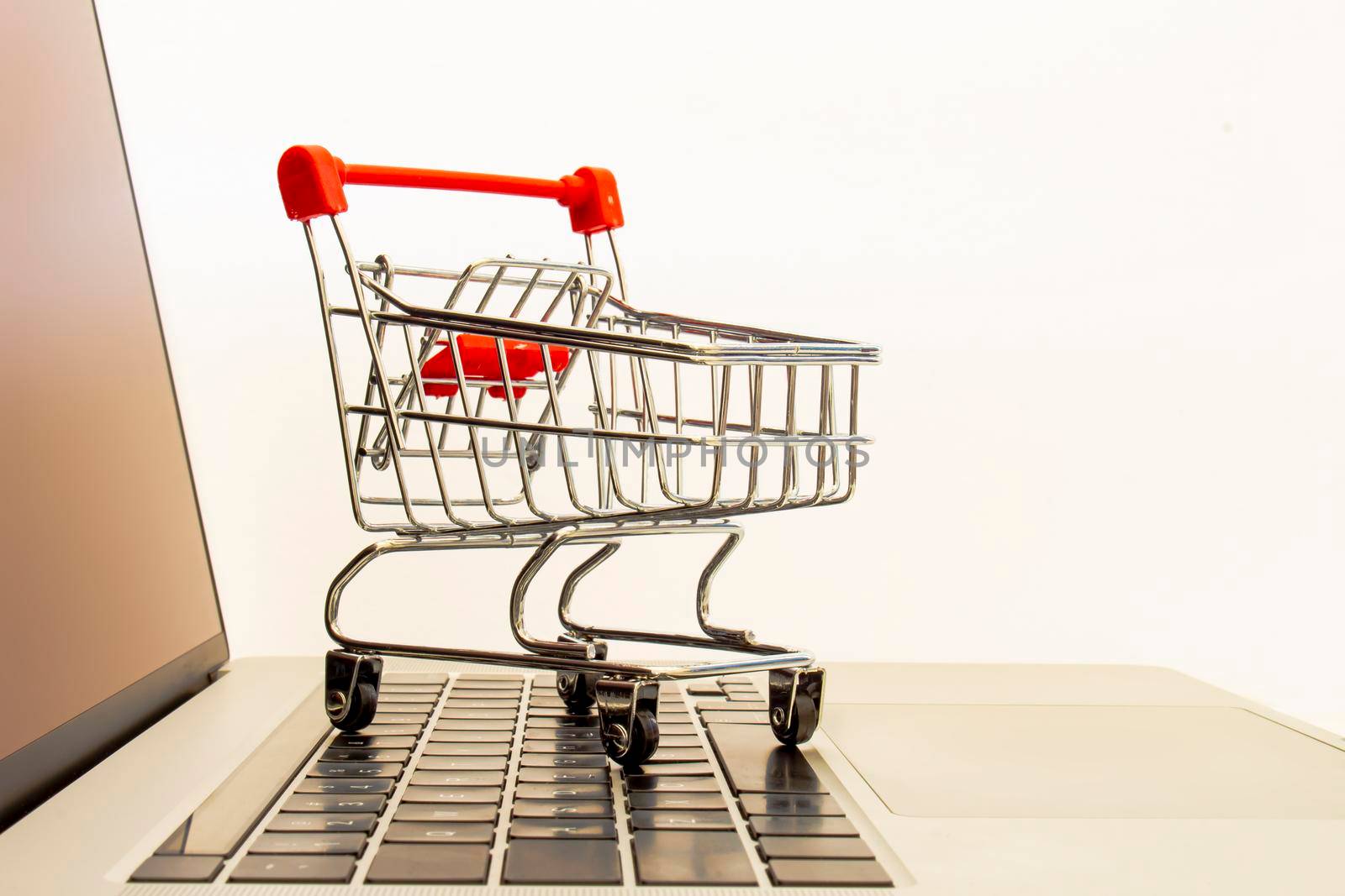 A Supermarket Hand Trolley, Mini Shopping Cart on top of a computer keyboard. Concept: Online shopping. by oasisamuel