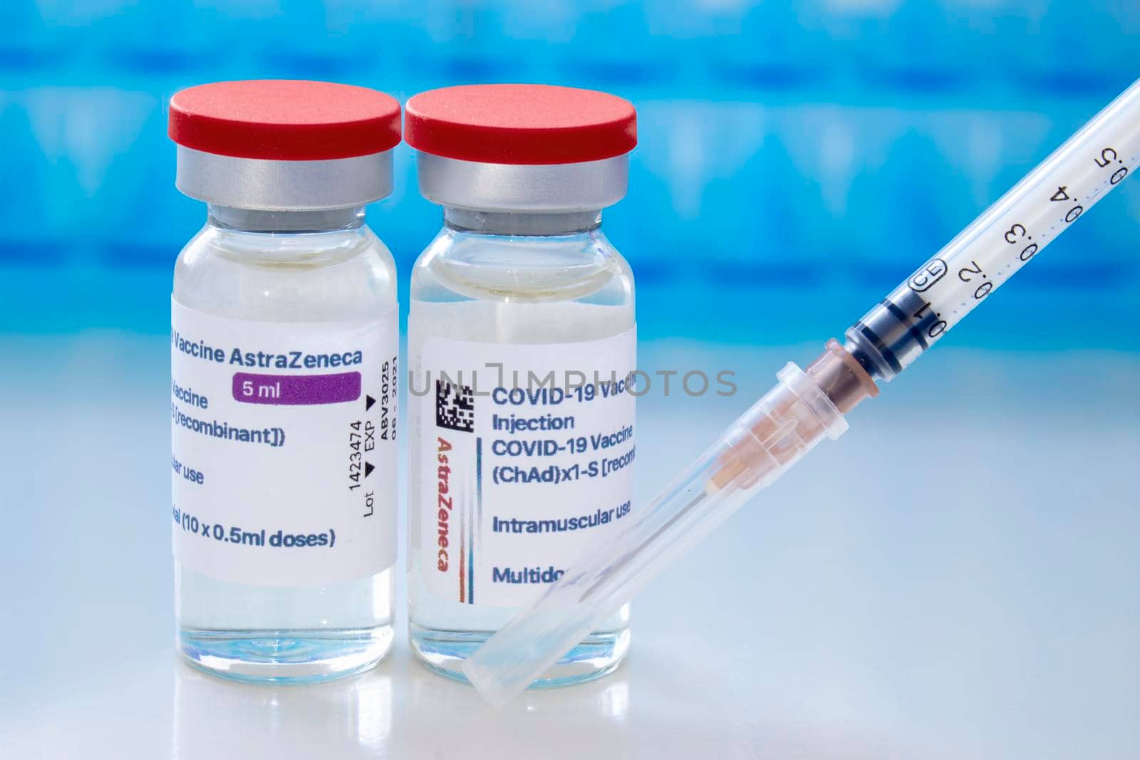 Calgary, Alberta, Canada. April 8, 2021. A couple of AstraZeneca dosis of Covid-19 vaccines on vial bottles and an injection syringe. by oasisamuel