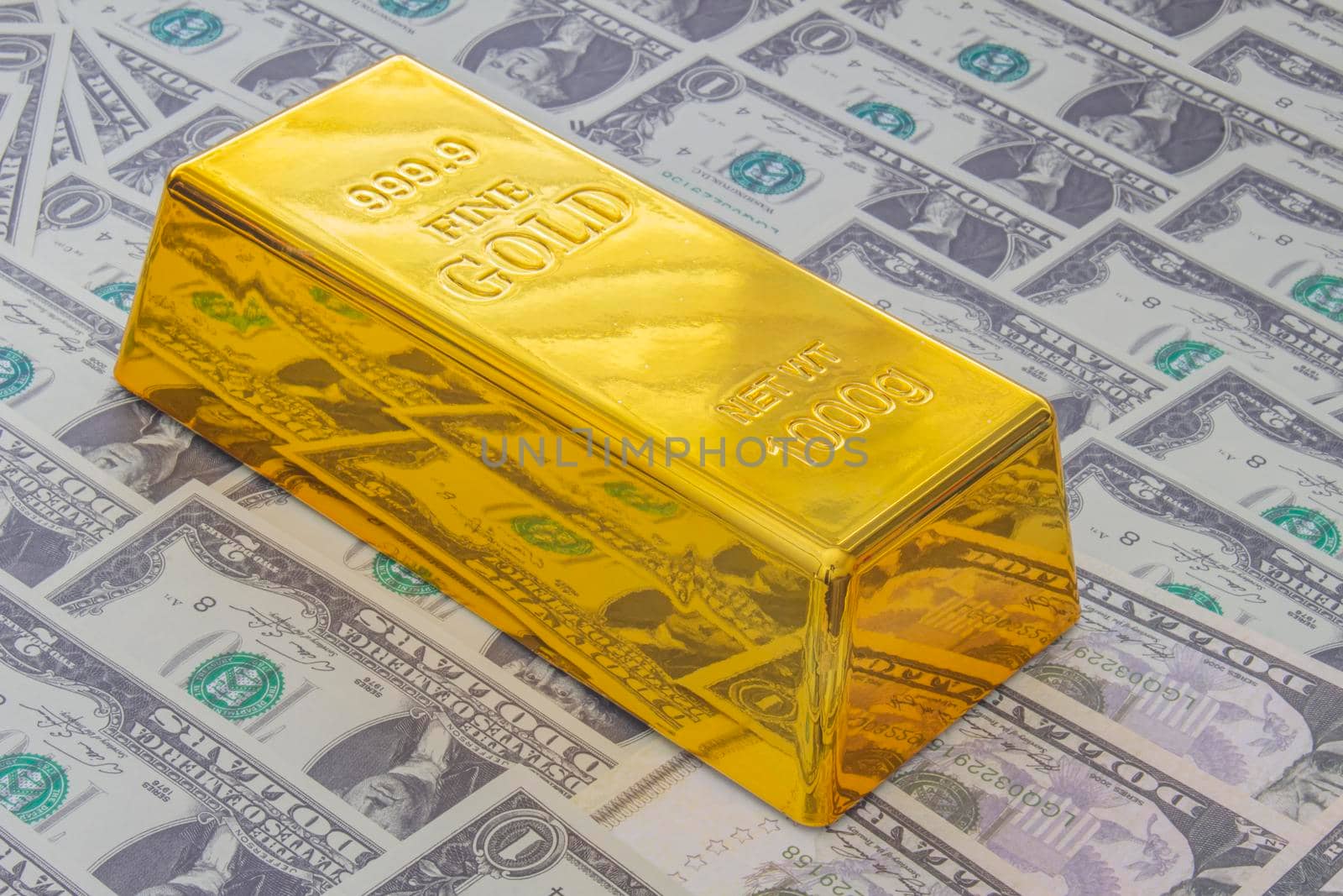Calgary, Alberta, Canada. April 10, 2021. A Gold Bar or Golden Brick Bullion on American USA currency.