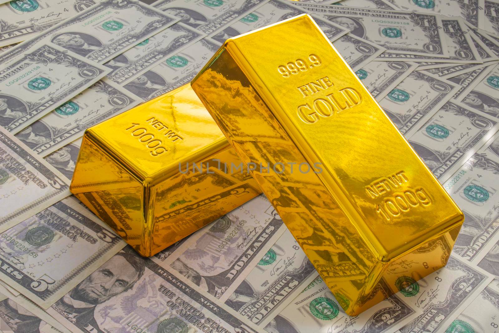 Calgary, Alberta, Canada. April 10, 2021. A Couple of Gold Bars or Golden Bricks Bullions on American USA currency. by oasisamuel