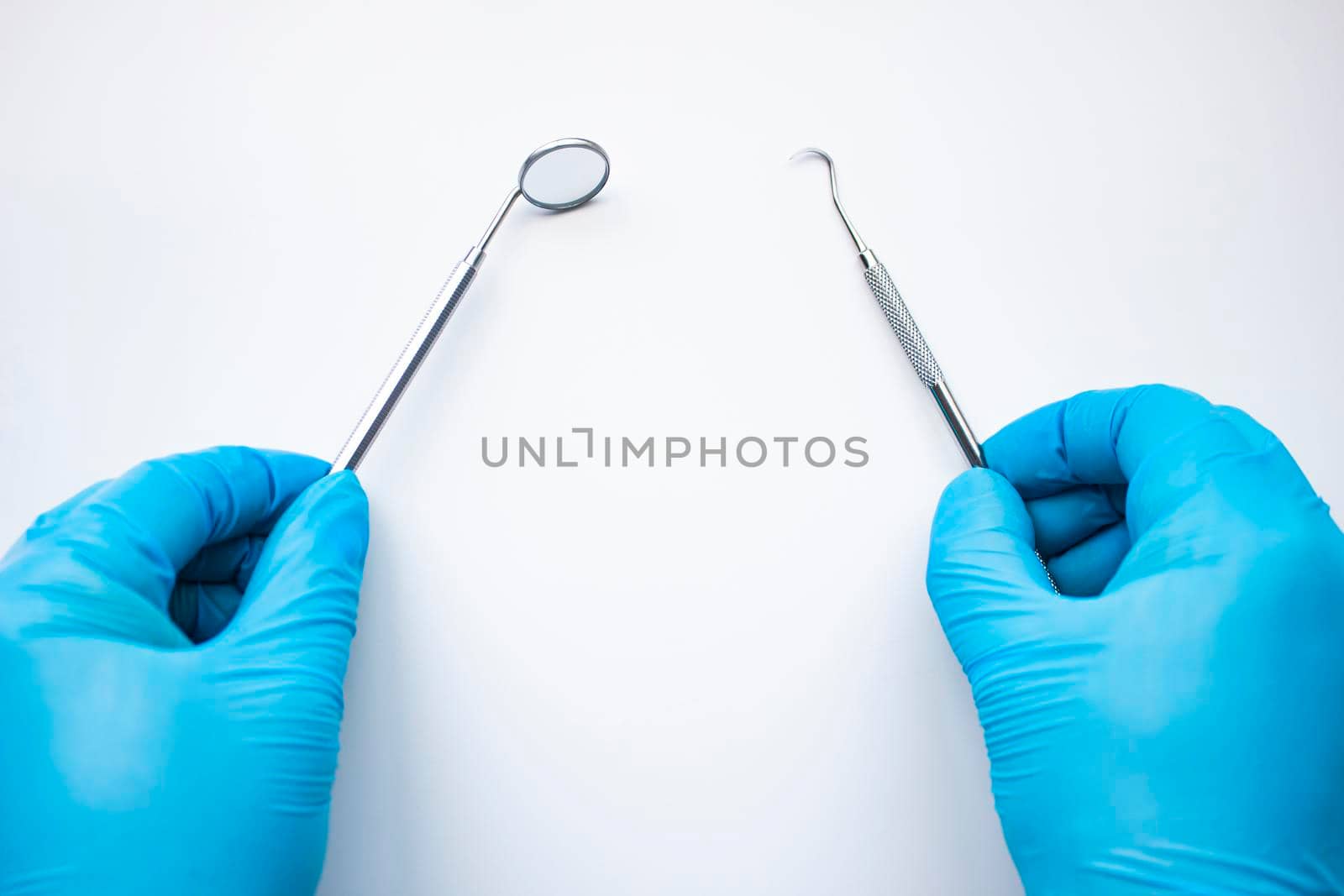 Dentist mirror and probe in hands isolated on white. Professional Dental Hygiene cleaning tools. Calculus and Plaque Remover Set, Dental Scaler And Mouth Mirror Instruments Hygienist tools.