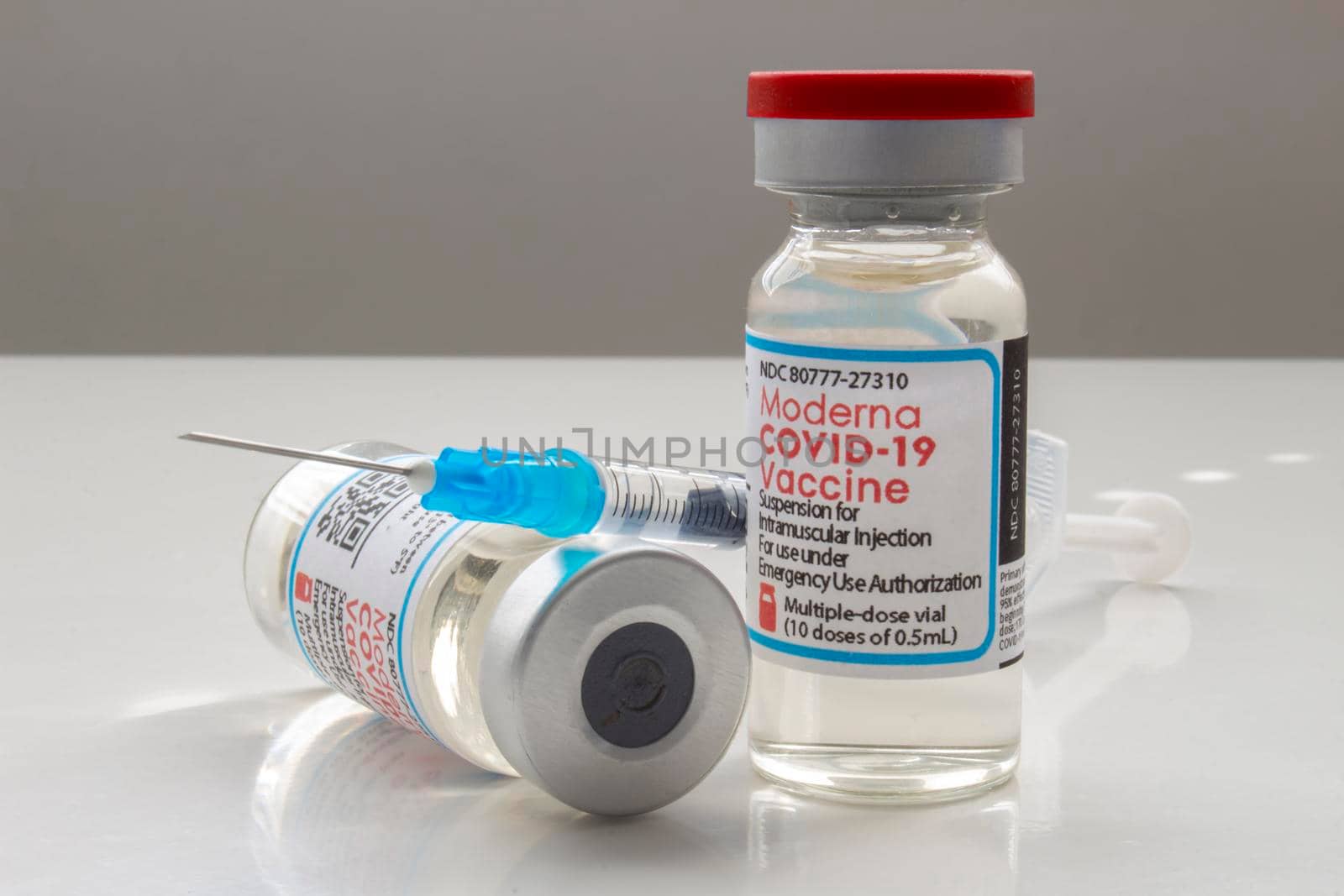Calgary, Alberta. Canada. April 02, 2021. A couple of Moderna Covid-19 vaccine vials with a syringe by oasisamuel
