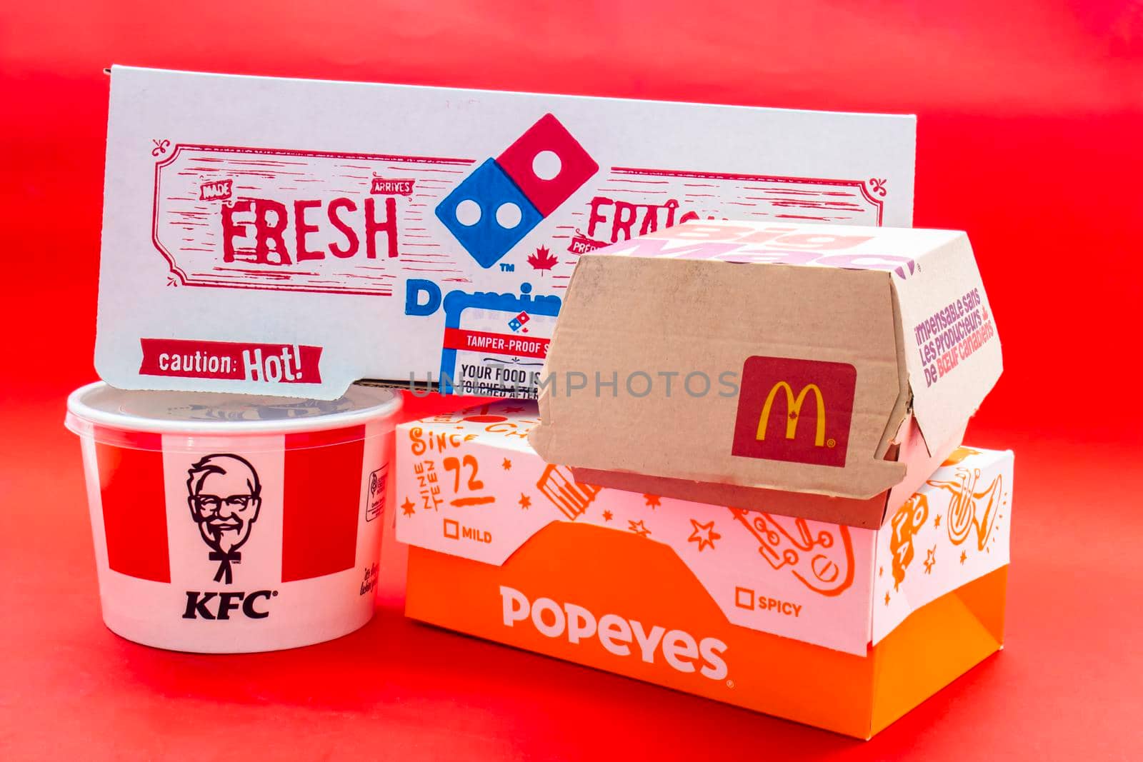 Calgary, Alberta, Canada. May 5, 2021. Several boxes of Fast food on a red background. by oasisamuel