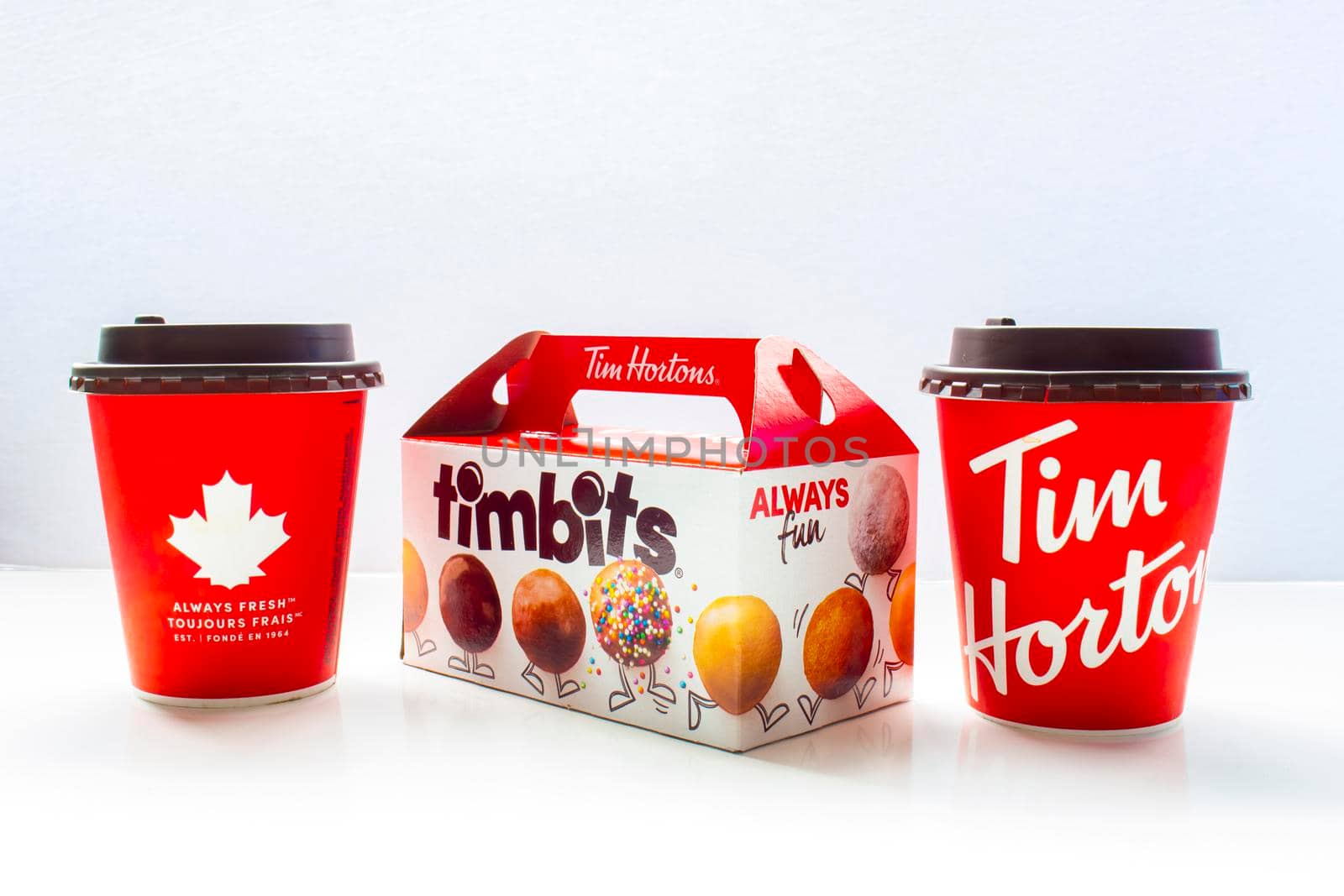 Calgary, Alberta Canada. May 7, 2021. A couple of Tim Hortons coffee cups with a timbits box. by oasisamuel
