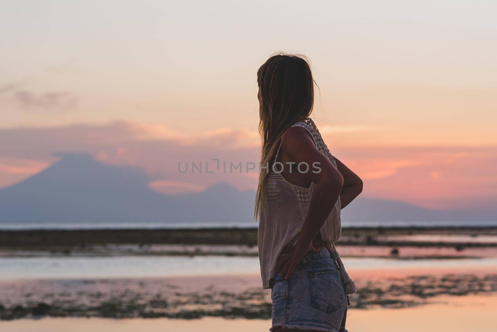 Young blonde girl on Gili Trawangan beach in Lombik, Indonesia at sunset time.