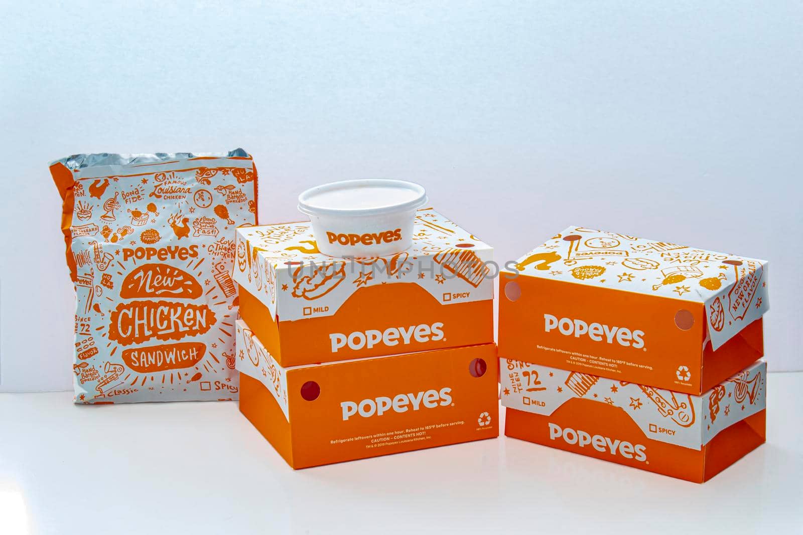 Calgary, Alberta, Canada. Oct 22, 2020. Popeyes boxes of chicken, burgers, cole salad and fries on a white background.