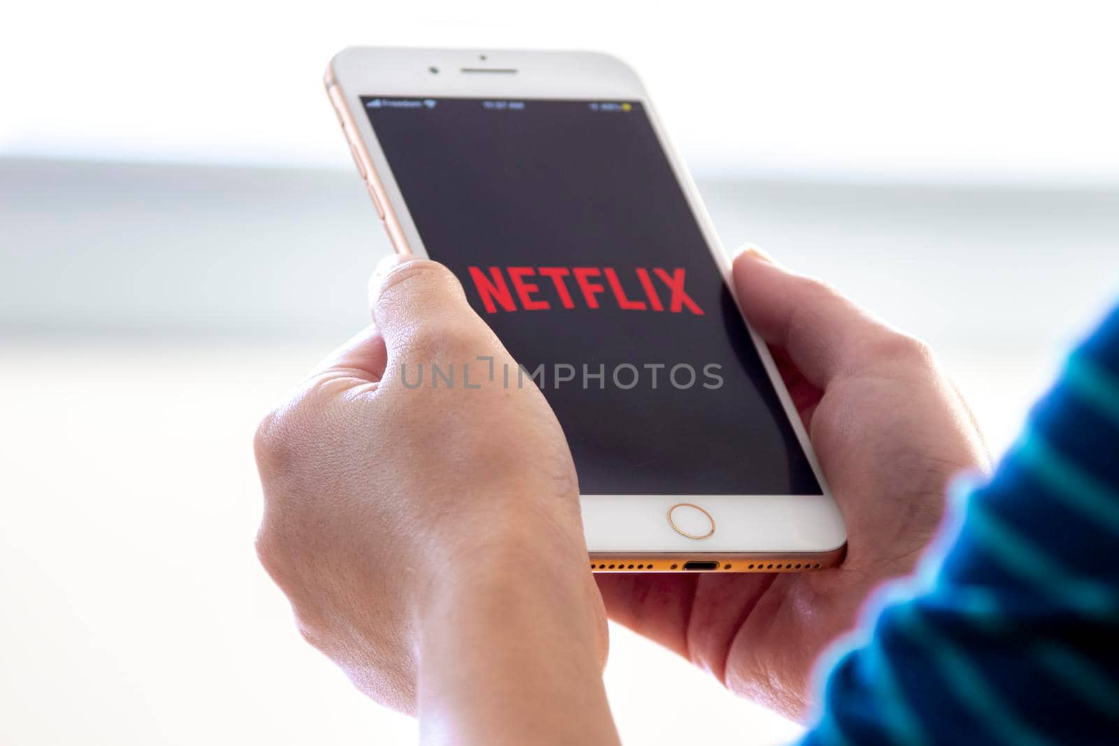 Calgary, Alberta. Canada Nov 28 2019: Woman holds an iphone plus with the Netflix app on her hands. Netflix release a new update of its online video streaming service.Illustrative by oasisamuel