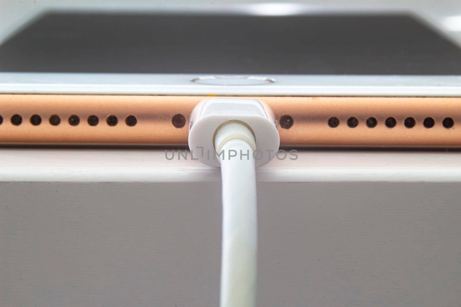 Calgary, Alberta. Canada July 5, 2020. Macro view of an iPhone Plus charging with a lightning USB Cable. by oasisamuel