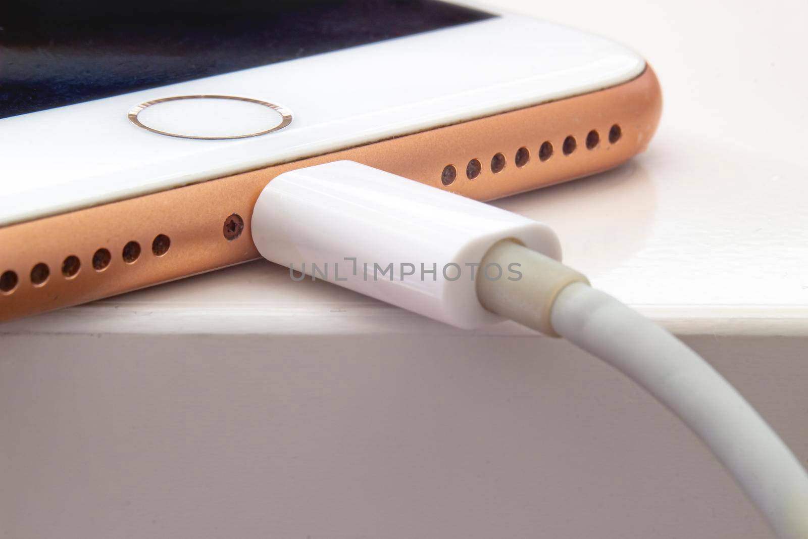 Calgary, Alberta. Canada July 5, 2020. Close up over view of an iPhone Plus charging with a lightning USB Cable. by oasisamuel