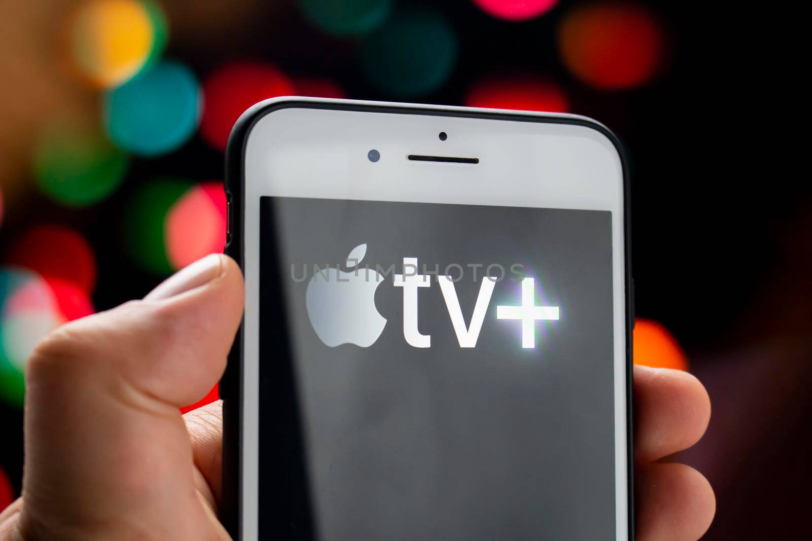 Calgary, Alberta, Canada. May 21, 2020. A person holding a white iPhone Plus with the Apple TV Plus logo on the screen