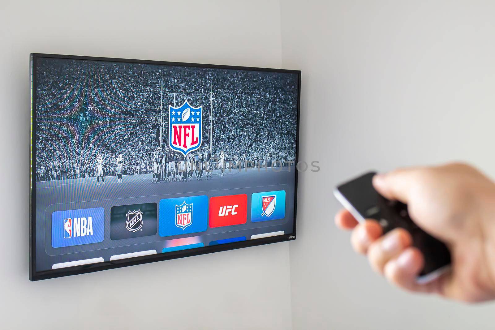 Calgary, AB, Canada. June 11, 2020. A person using an apple tv remote using the NFL application. Concept watching American Football. by oasisamuel