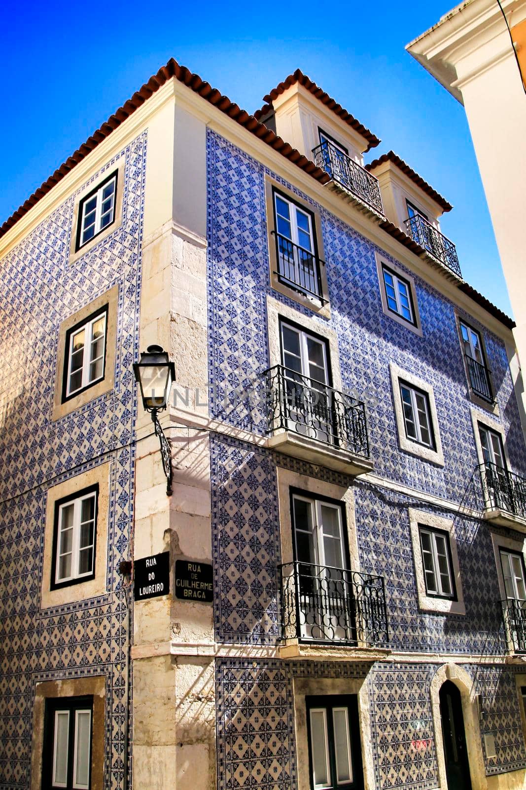 Old colorful and beautiful facades with vintage streetlight in Lisbon streets in Spring.