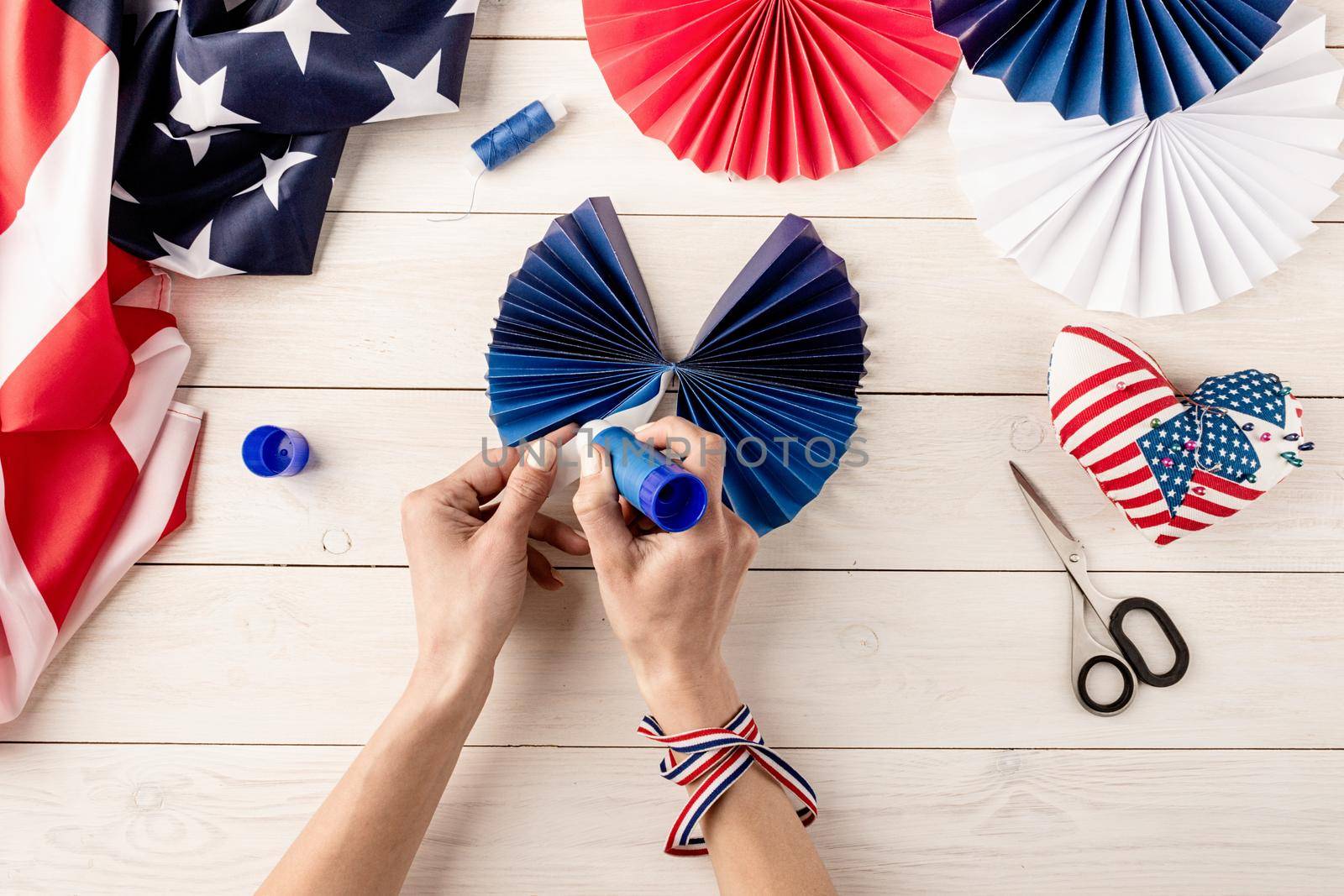 Gift idea, decor July 4, USA Independence Day. Step by step tutorial DIY craft. Making colorful paper fans, step 6 - fold and glue the sides. Flat lay top view