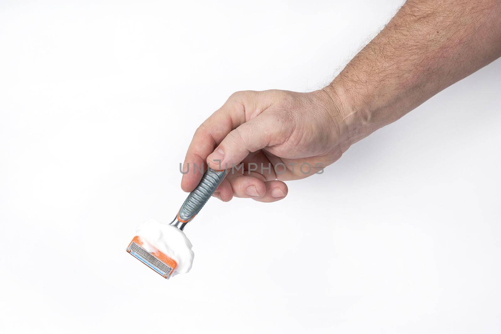 Hand holds a shaving razor with shaving foam on a white background, a template for designers. Close-up