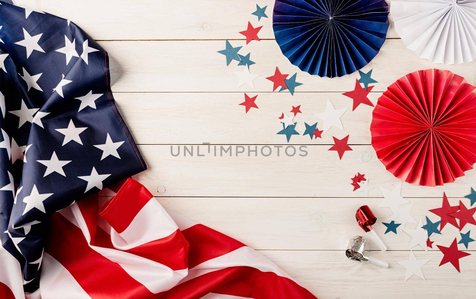 Decorations for 4th July, Independence Day USA. Paper fans, national flag, stars and noisemakers on white wooden background by Desperada