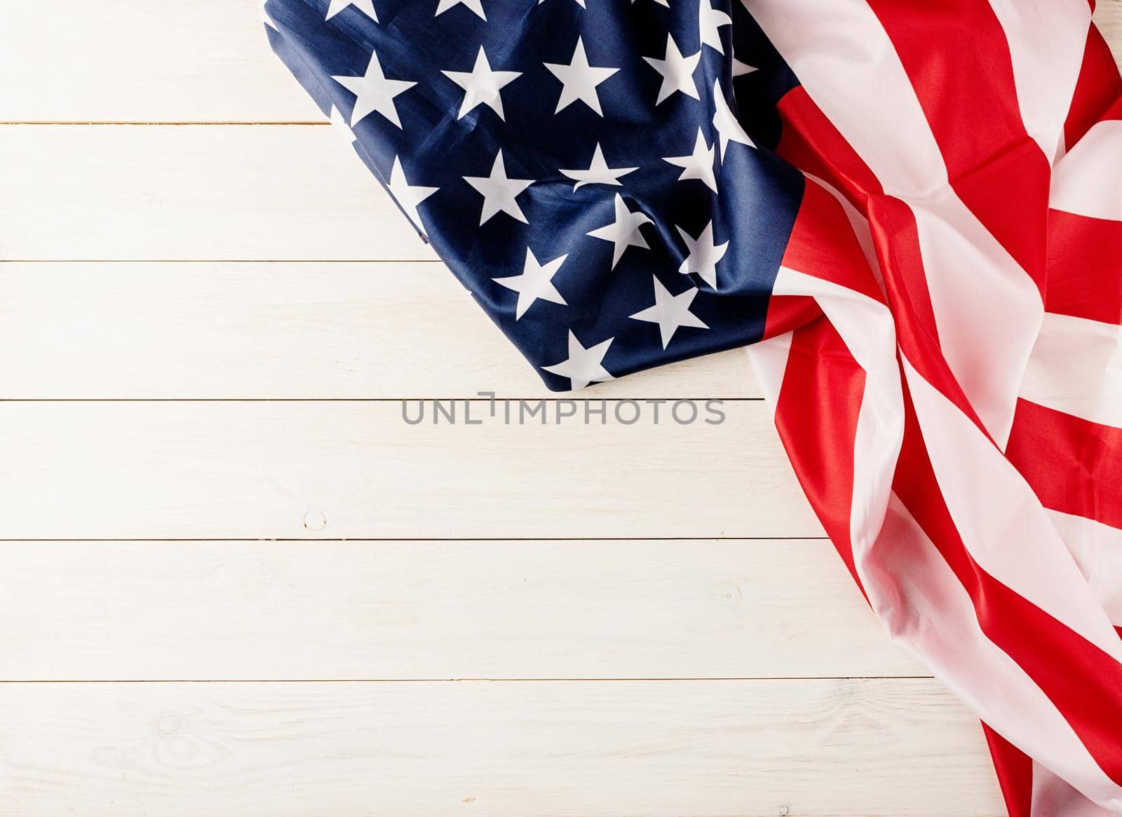 Top view of USA national flag on white wooden background, flat lay by Desperada