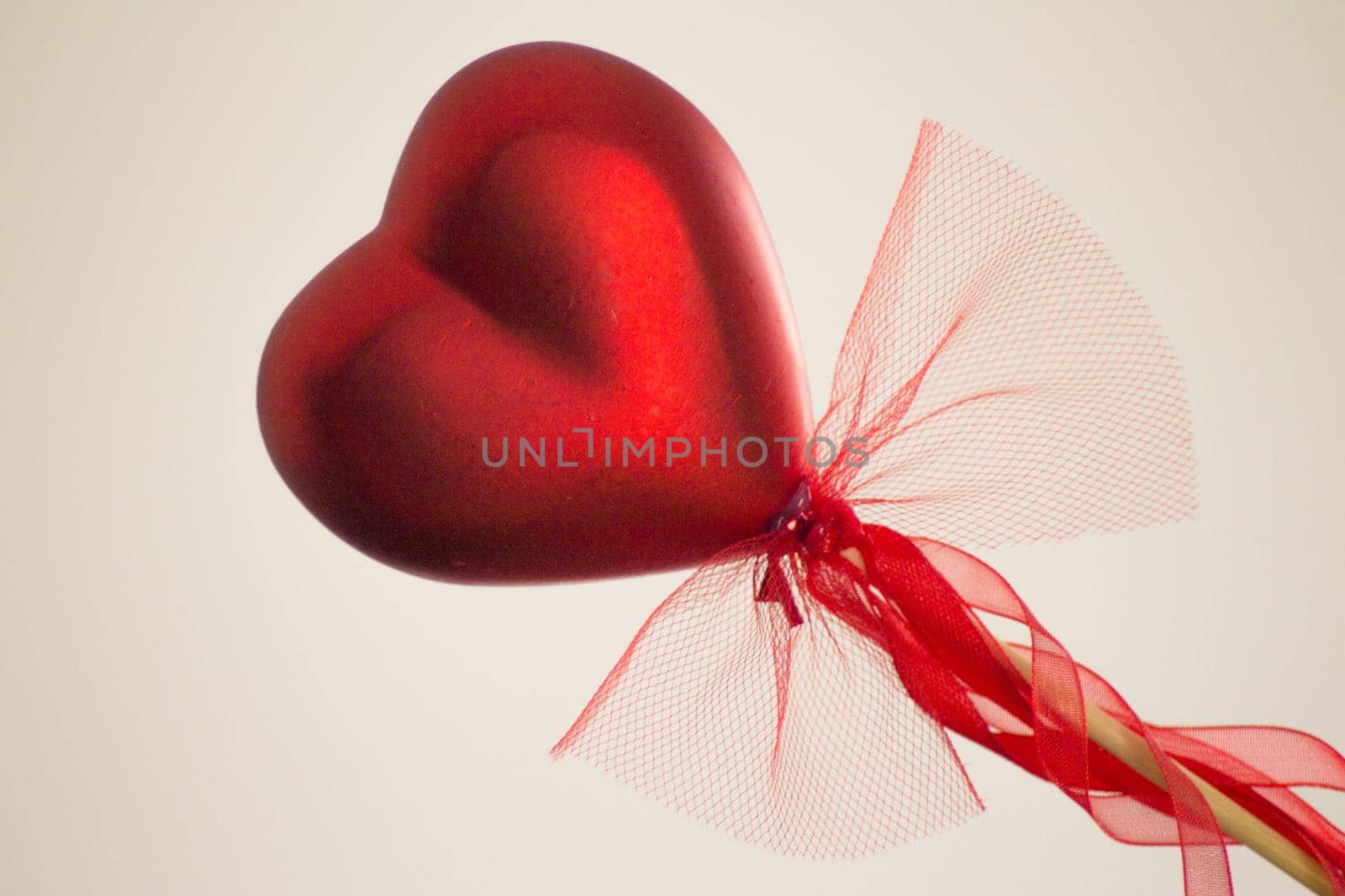 Red heart attached to a stick with a bow hanging by GemaIbarra