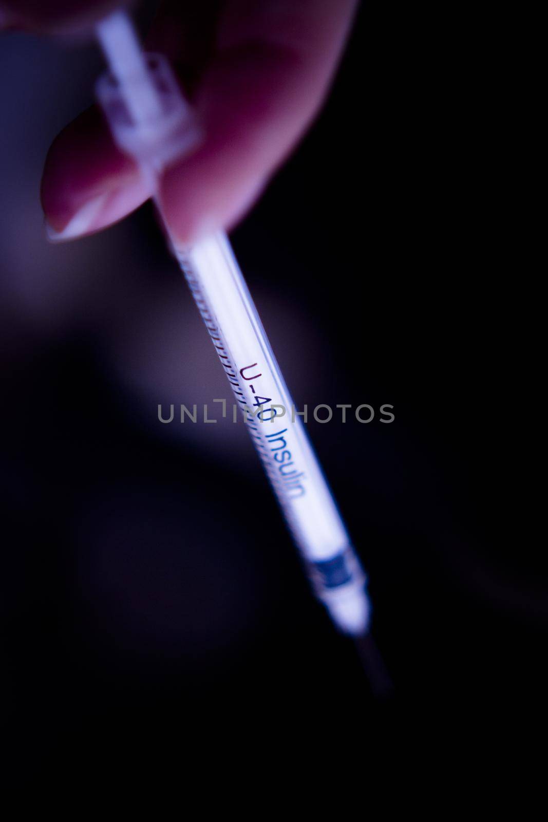 Insulin injecting syringe held by nurses hand. Copy space