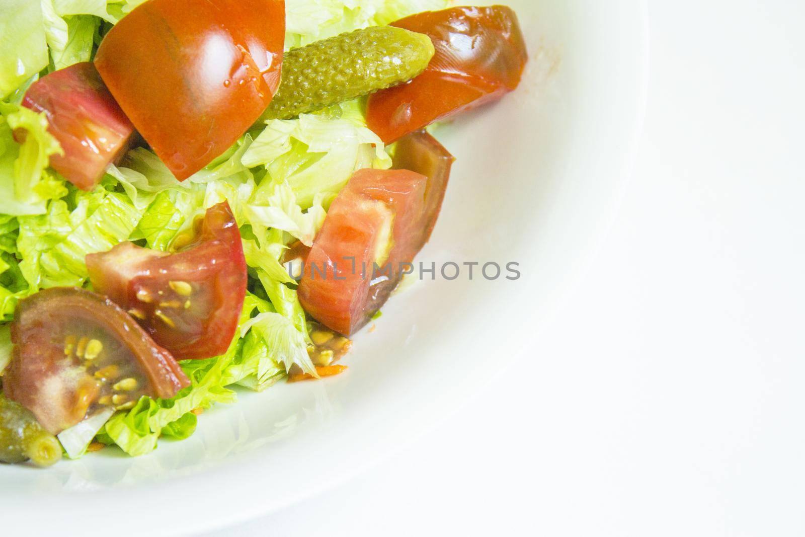 Lettuce salad with tomato and pickles. Raw food