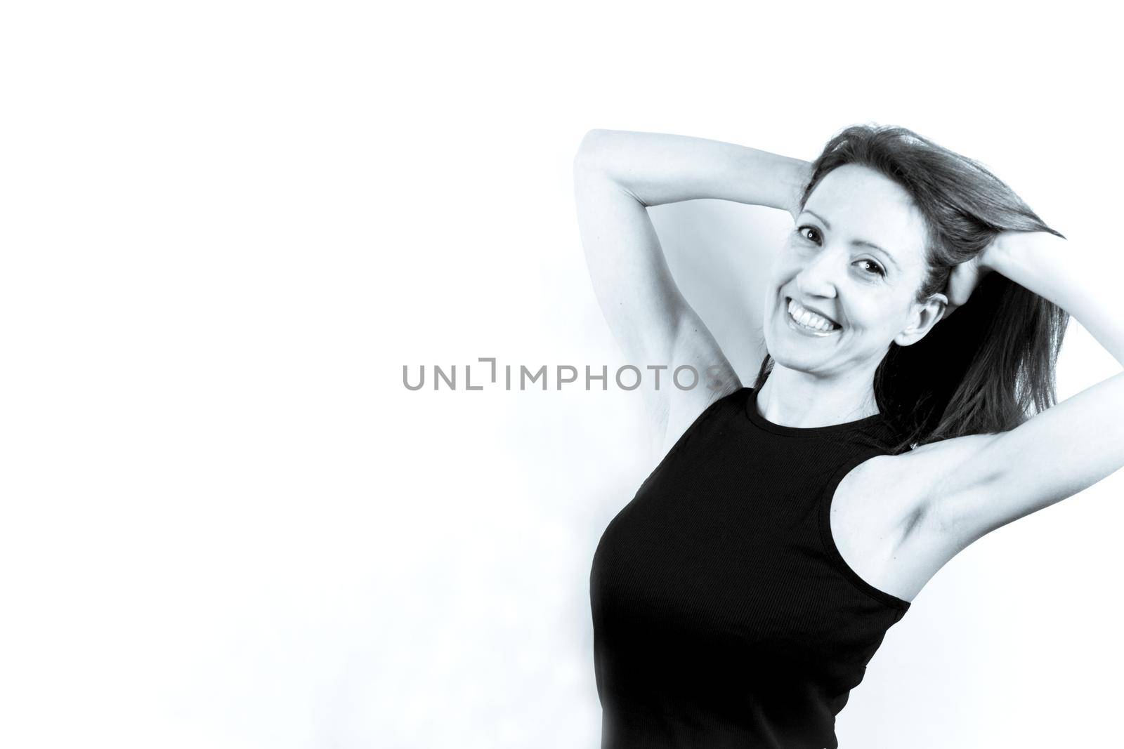 Forty year old woman with happy, joyful and positive expression. Black tshirt and light background