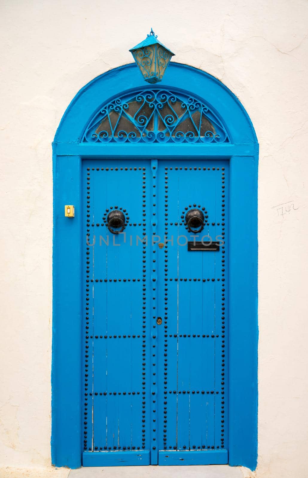 Traditional blue door with ornament and lantern from Sidi Bou Said. Culture of Tunisia