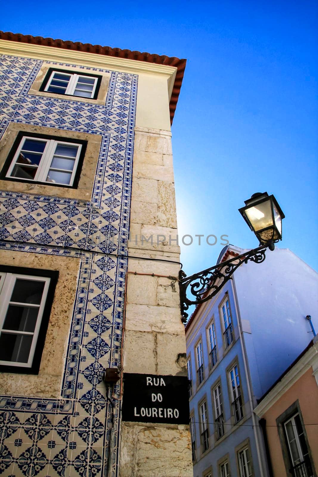 Old colorful and beautiful facades with vintage streetlight in Lisbon streets in Spring.
