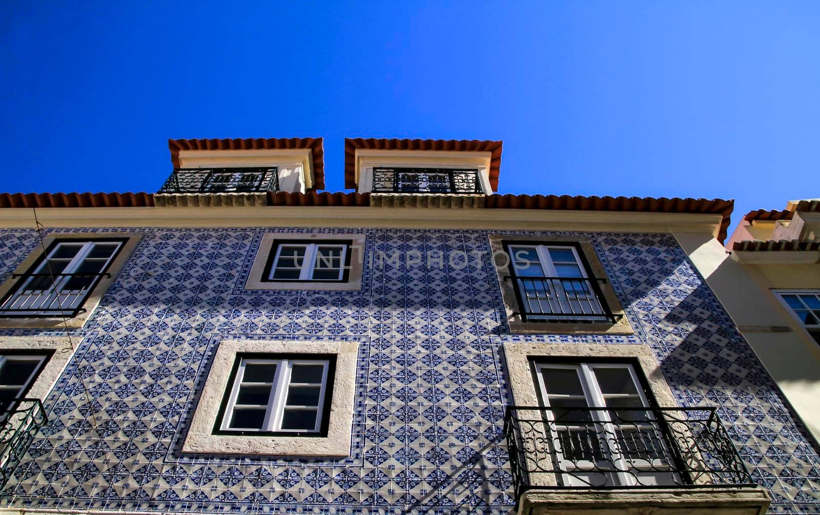 Old colorful and beautiful facades with vintage streetlight in Lisbon streets in Spring.