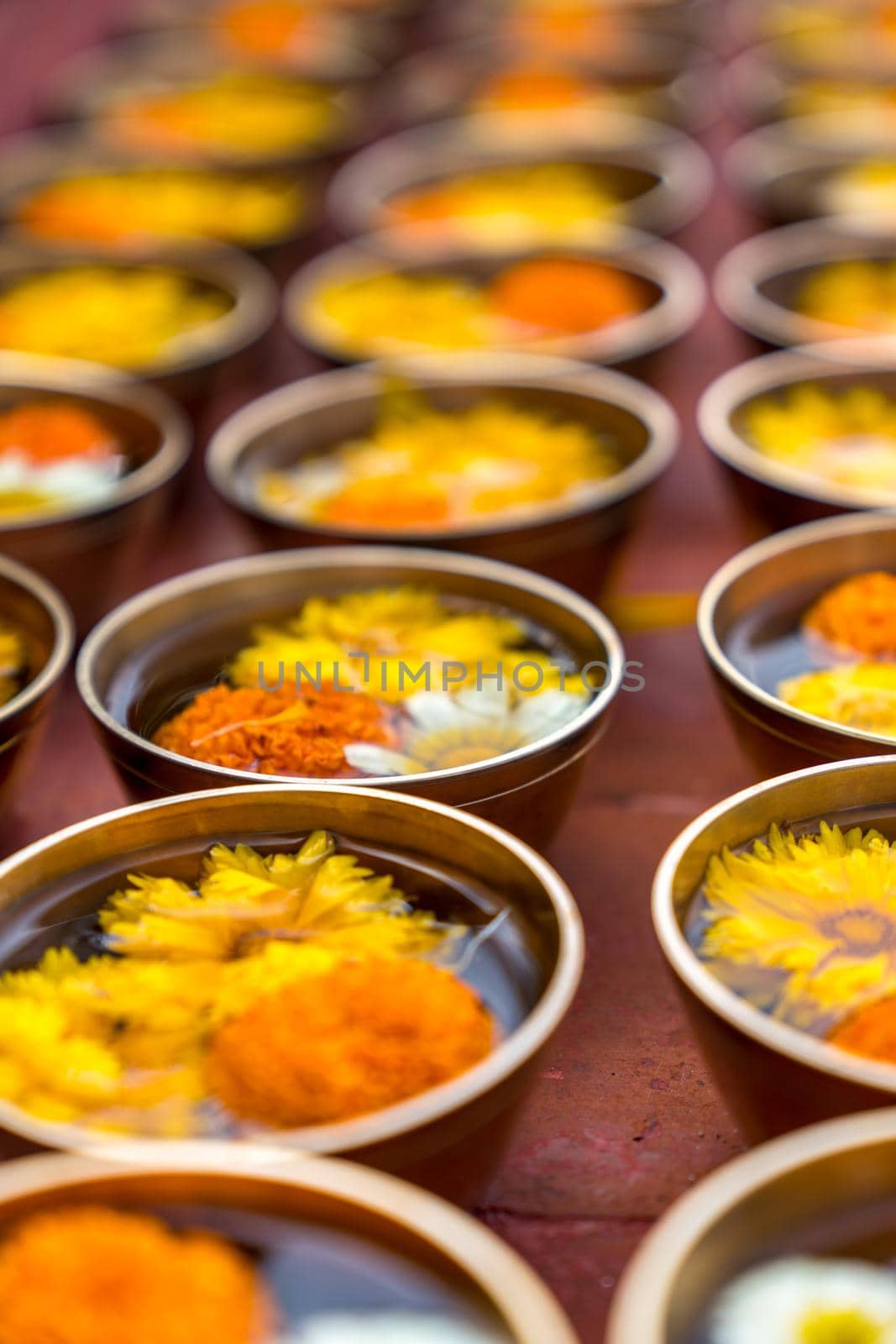 Buddhist flower offerings or gifts in bowls and rows. Buddhism religion offering in a temple