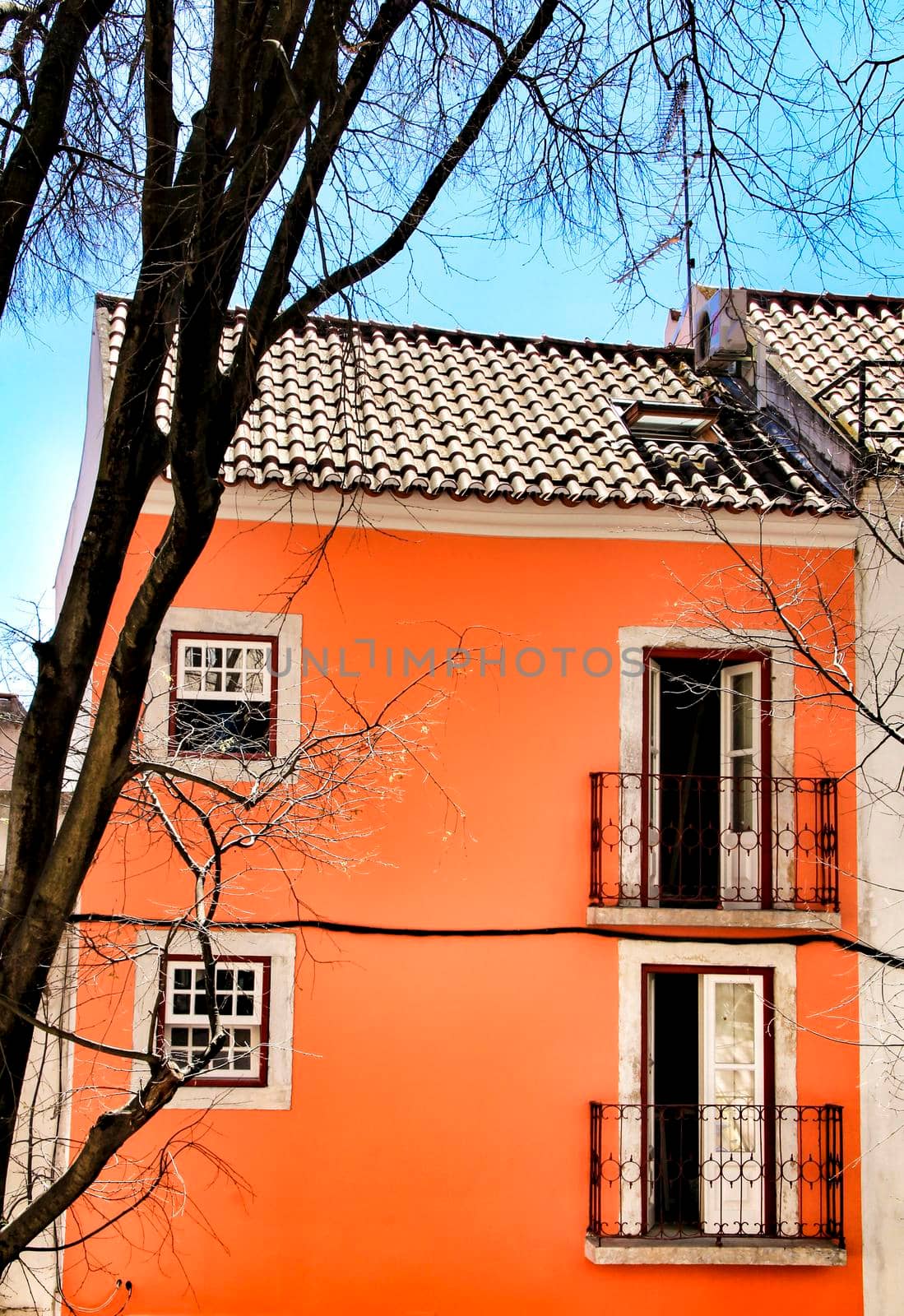 Old colorful and beautiful facades with vintage streetlight in Lisbon streets in Spring. Clothesline in the facade with hanging clothes