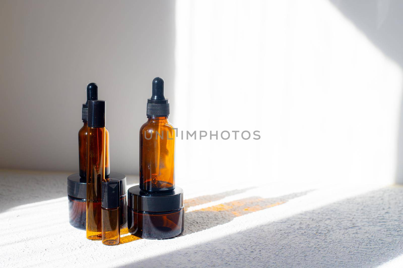 Cosmetic jars with oils on a white background . Light and shadows. Minimalism. Copy space. Cosmetology. Skin care. Cosmetic bottles. spa treatments