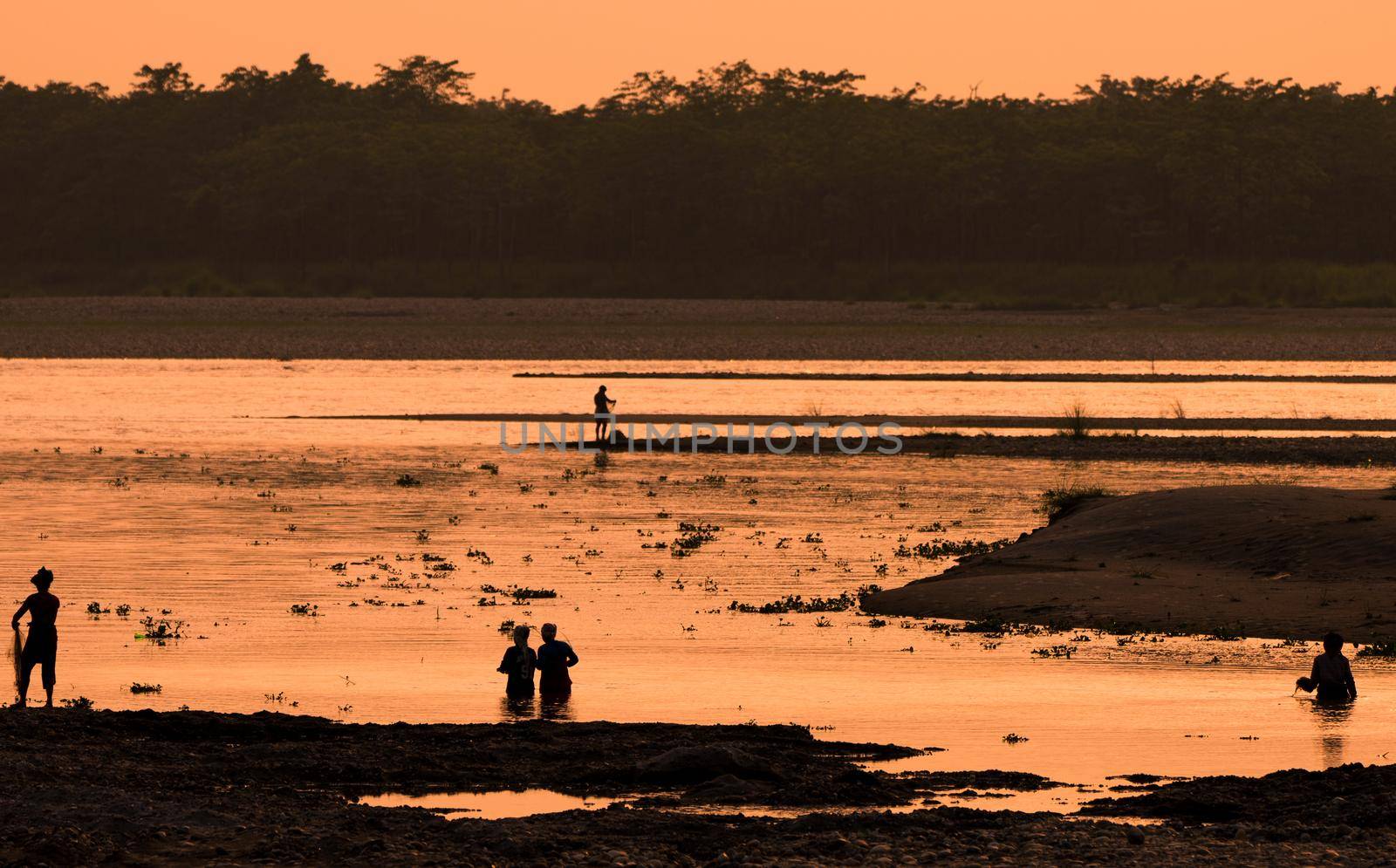 Asian Women fishing in the river. silhouette at sunset. Village life in Asia