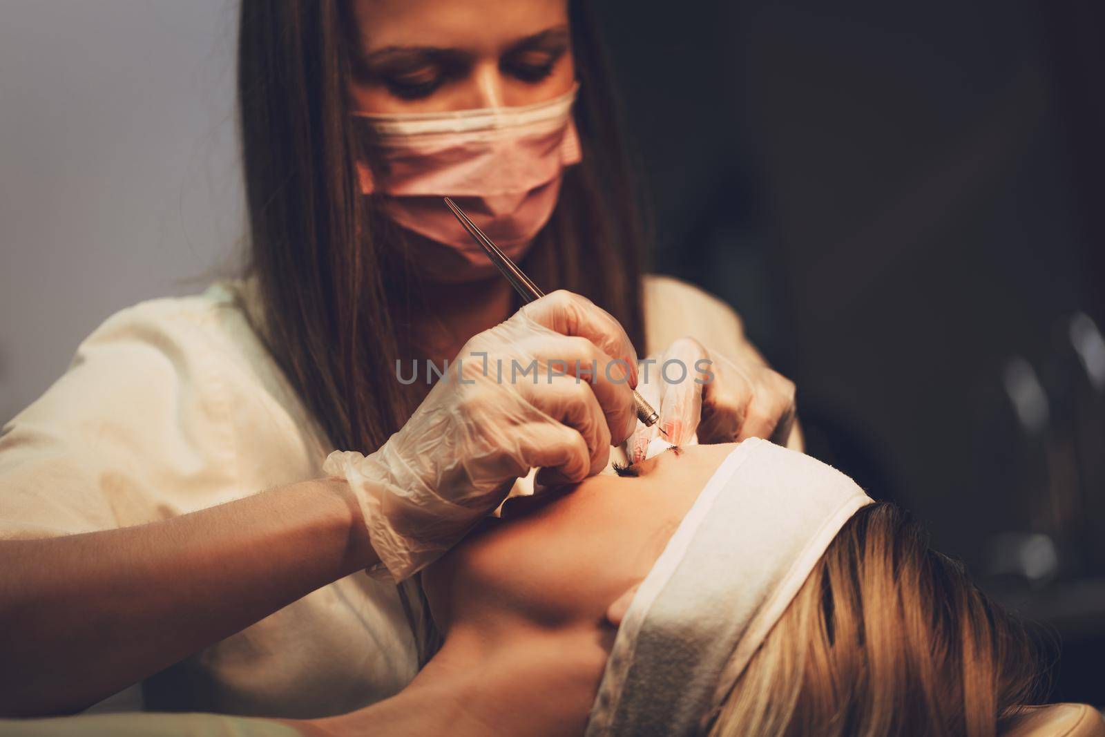 Beautician applying japanese method of drawing on eyebrows to model.