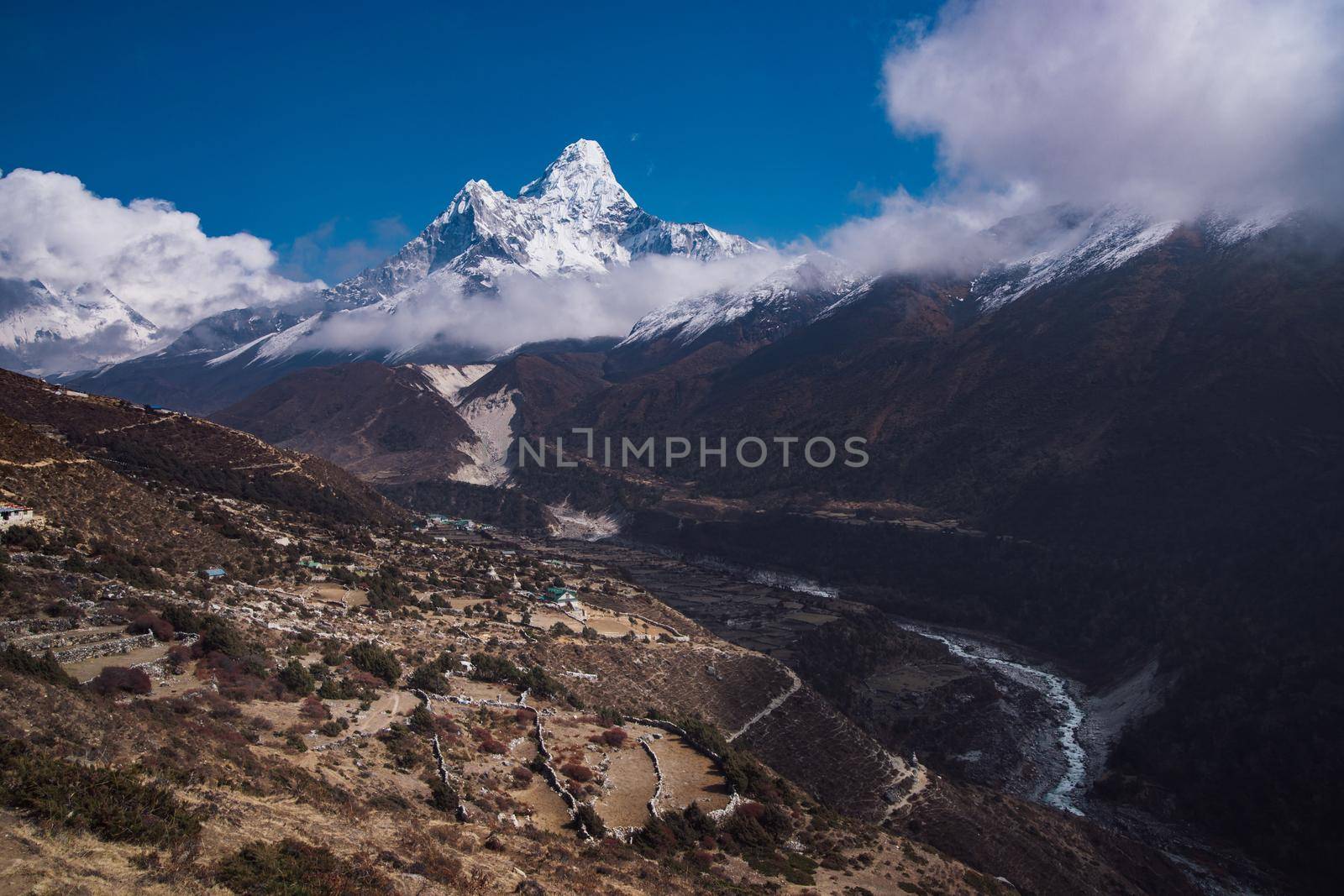 Ama Dablam summit or peak and Nepalese village in Himalayas. Travel trekking and tourism in Nepal