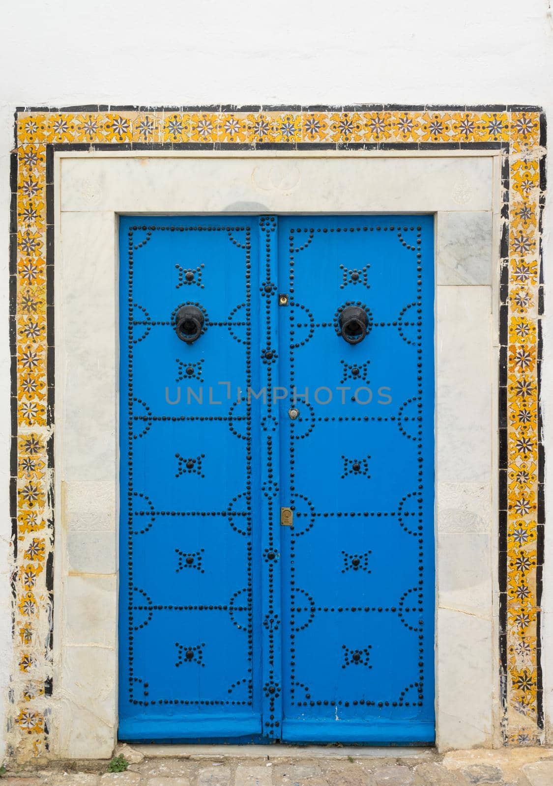 Blue aged door with ornament and tiles from Sidi Bou Said in Tunisia