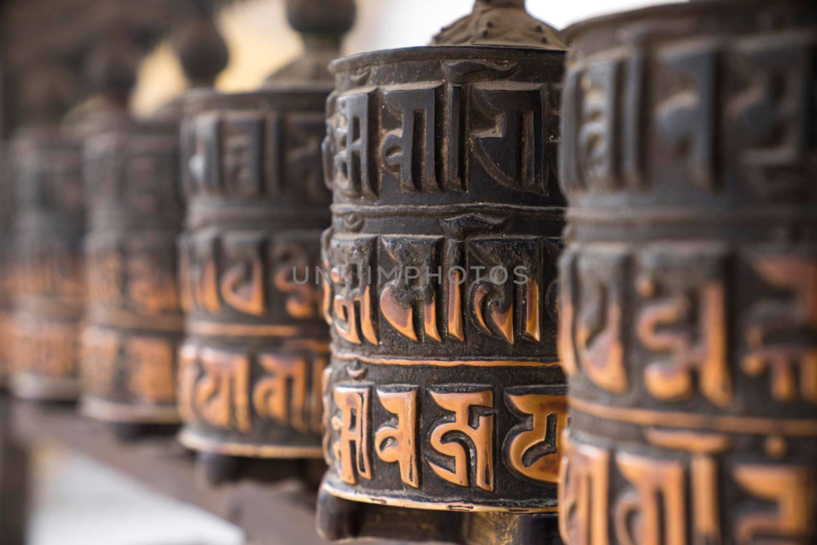 Buddhist prayer wheels in row  by Arsgera