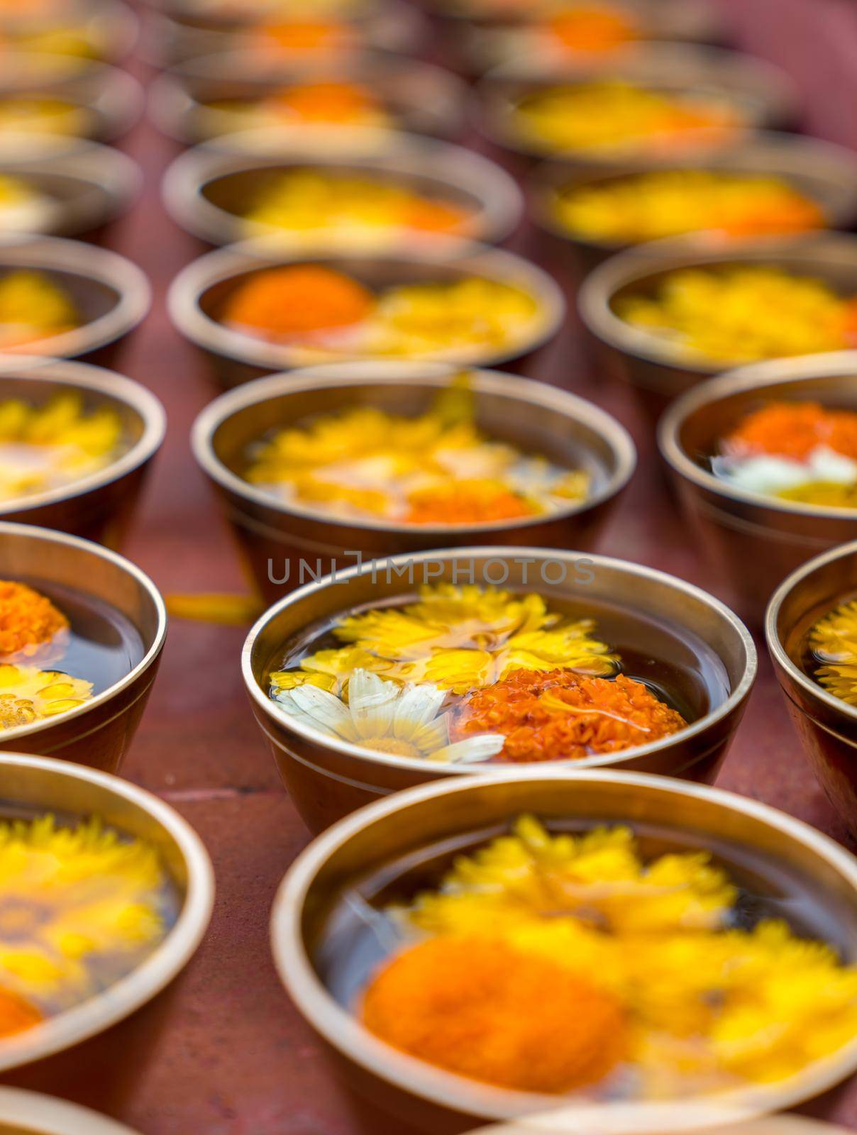 Buddhist flower offerings or gifts in bowls and rows. Buddhism religion offering in a temple