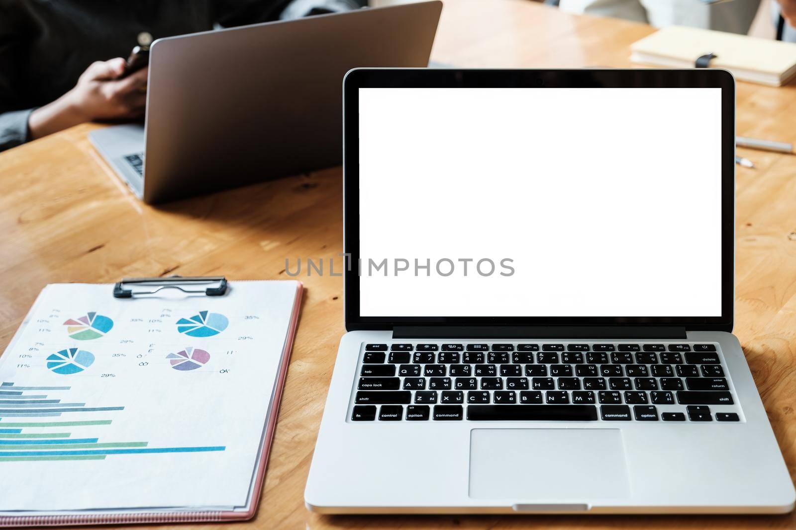 White blank screen tablet on modern working desk with business working on background