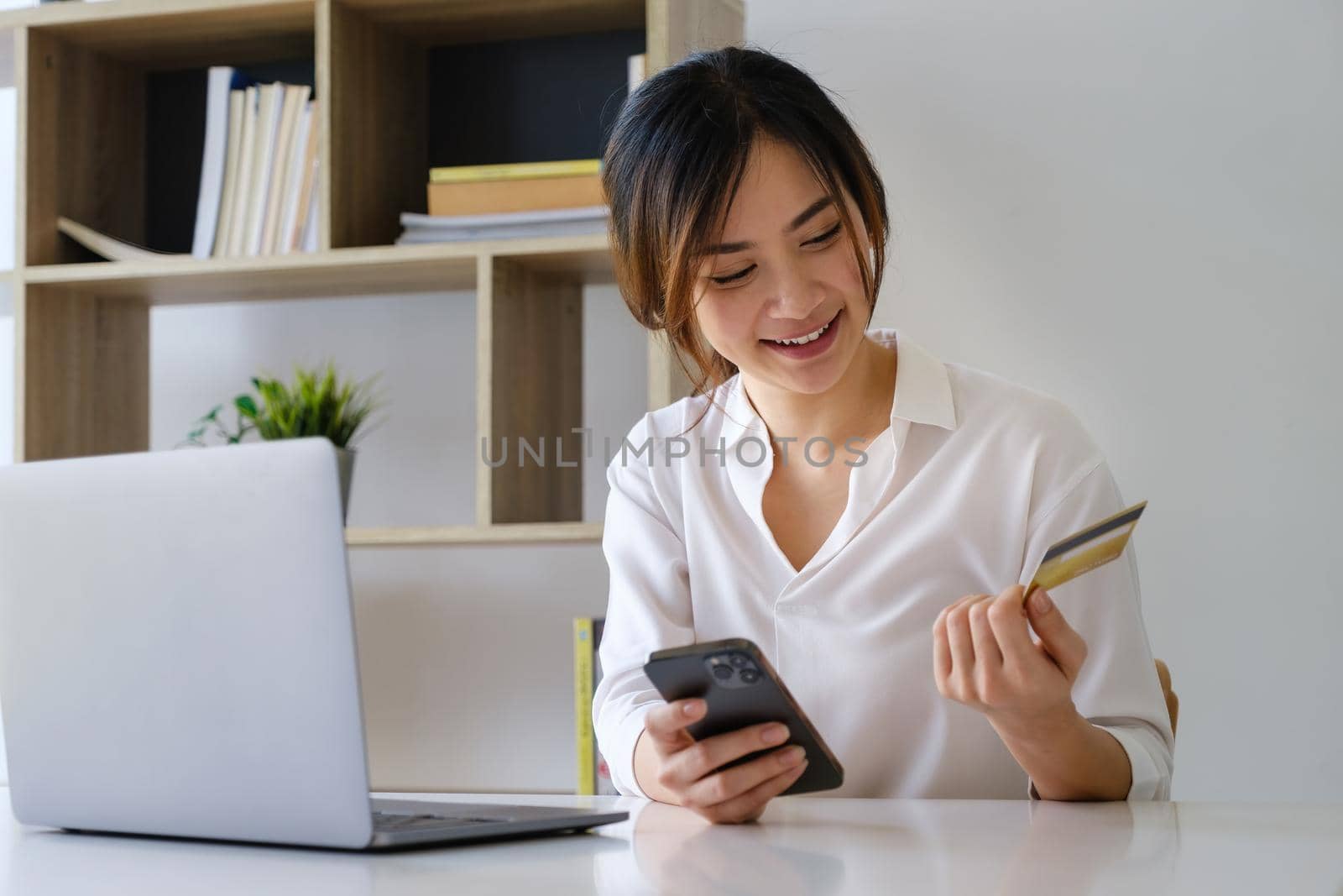 Woman enjoy with online shopping application and looking at credit card for fill number to payment.